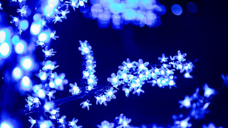 A street is lit up with Christmas lights and decorated with light trees and branches. Christmas and New Year illuminations. Festive background.の写真素材