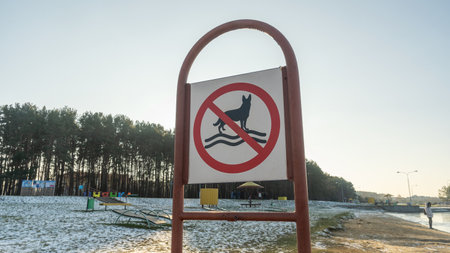 A clear sign on the beach stating "No Dogs Allowed" to ensure a safe and enjoyable environment for all visitors, prohibiting swimming with pets in the area.の写真素材