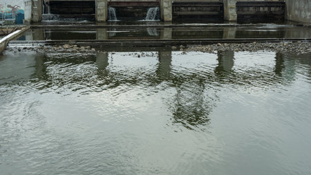 A winter scene of a river dam, showcasing the engineering marvel controlling water release. The icy landscape highlights the dam's role in managing water flow and preventing flooding.の写真素材