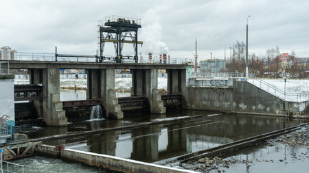 A winter scene of a river dam, showcasing the engineering marvel controlling water release. The icy landscape highlights the dam's role in managing water flow and preventing flooding.の写真素材