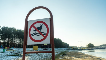 A clear sign on the beach stating "No Dogs Allowed" to ensure a safe and enjoyable environment for all visitors, prohibiting swimming with pets in the area.の写真素材