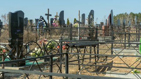 Gravestones at a quiet cemetery honor the memory of loved ones, symbolizing faith, resurrection, and...