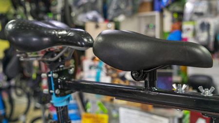 Closeup Of A Sleek Black Leather Bicycle Saddle In A Vibrant Sports Equipment Store. Detailed View Of A Black Bicycle Seat With Metal Hardware On Display In A Retail Shop.の写真素材