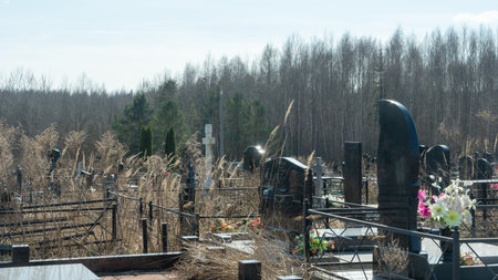 Gravestones at a quiet cemetery honor the memory of loved ones, symbolizing faith, resurrection, and...