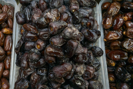 Date fruit on market stall fresh natural tropical healthy snack. Close up of ripe brown dates...