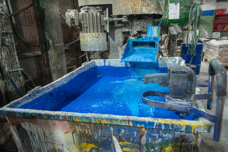 Vibrant blue paint tank in a bustling factory setting, capturing the essence of industrial artistry....