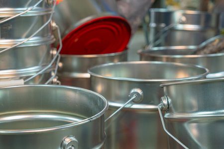 Rows of empty tin cans prepared for vibrant paint production. Empty vessels awaiting paint. Empty...