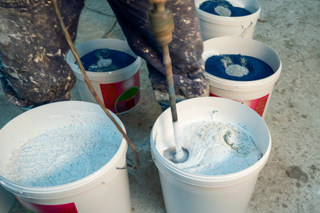 Production of decorative plaster. Materials for repair and decoration. Closeup of blue decorative...