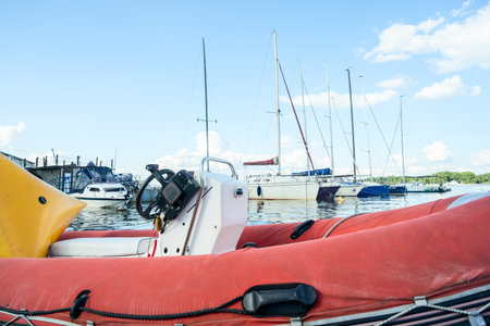 Inflatable rescue boat equipped with steering console. Safe haven for exploration a red inflatable boat rests peacefully at the pier ready to embark on new adventures.の写真素材