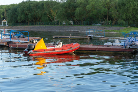 Inflatable rescue boat equipped with steering console. Safe haven for exploration a red inflatable boat rests peacefully at the pier ready to embark on new adventures.の写真素材