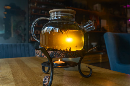 Golden hour tea ritual featuring herbal tea in a glass teapot symbolizing harmony warmth and shared...