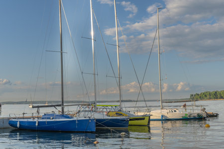 Sailboats docked at quiet marina under clear blue sky. Yachts moored quietly in the harbor, poised for new journeys beneath an endless sky of freedom and possibility.の写真素材