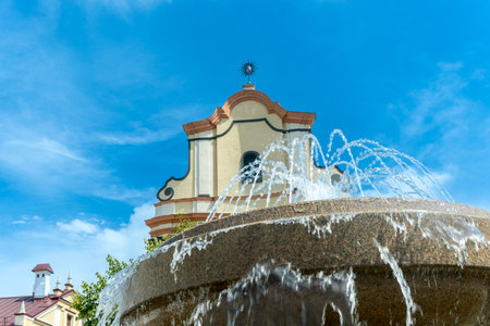 Fountain in front of historic building. Elegant fountain with flowing water in front of old stone...