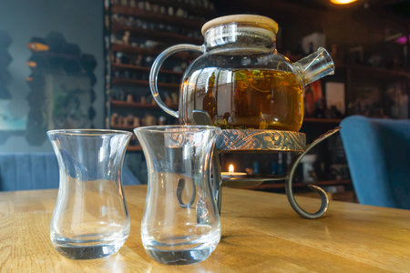 Golden hour tea ritual featuring herbal tea in a glass teapot symbolizing harmony warmth and shared...