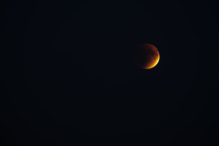 Blood red moon in night sky. Celestial prophecy. Lunar eclipse in dramatic red color with a cosmic...