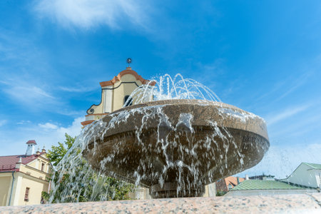 Fountain in front of historic building. Elegant fountain with flowing water in front of old stone...