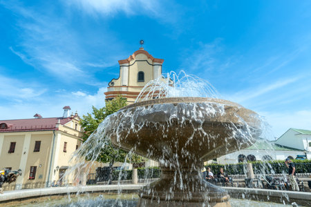 Fountain in front of historic building. Elegant fountain with flowing water in front of old stone...