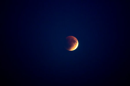 Blood red moon in night sky. Celestial prophecy. Lunar eclipse in dramatic red color with a cosmic...
