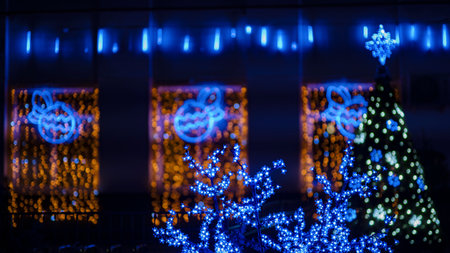 A street is lit up with Christmas lights and decorated with light trees and branches. Christmas and New Year illuminations. Festive backgroundの写真素材