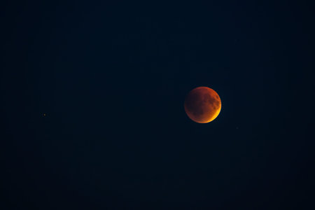 Blood red moon in night sky. Celestial prophecy. Lunar eclipse in dramatic red color with a cosmic...