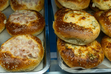 Homemade baked buns with savory cheese and meat filling. Delicious variety of snack vatrushka buns...