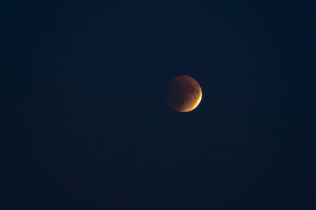 Blood red moon in night sky. Celestial prophecy. Lunar eclipse in dramatic red color with a cosmic...