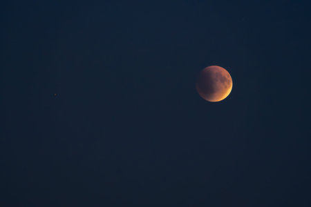 Blood red moon in night sky. Celestial prophecy. Lunar eclipse in dramatic red color with a cosmic...