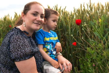 Portrait Of A Young Mother With Her 2 Years Old Boy Playing In A Field Of Poppiesの写真素材