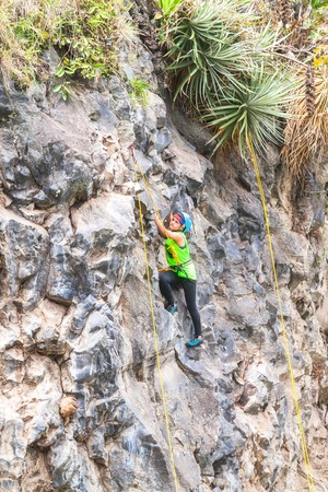 Banos, Ecuador - 30 November 2014: Basalt Challenge Of Tungurahua, Teen Latin Girl Climbing A Vertical Rock Wall, South America In Banos On November 30, 2014のeditorial素材