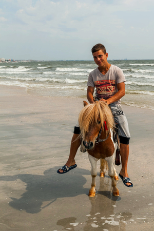 Mamaia, Romania - 7   2014: Portrait Of Young Boy Riding His Pony On The Beach In Mamaia On   7, 2014のeditorial素材