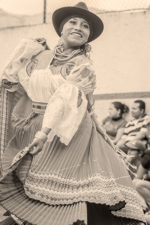 Banos De Agua Santa, Ecuador - November 29, 2014: Unidentified Youth Indigenous Woman Dancing On City Streets Of Banos De Agua Santa, South America, Black And White Style In Banos De Agua Santa On November 29, 2014のeditorial素材