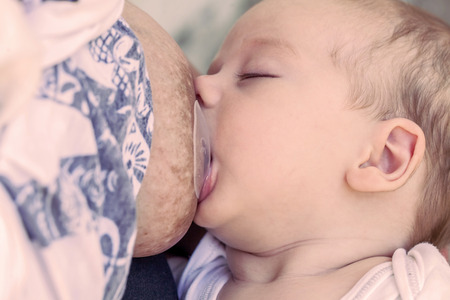 Mother Breast Feeding And Hugging Her Newborn Baby Boy
