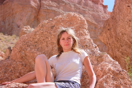 Young girl portrait in canyon, girl sitting on stoneの写真素材
