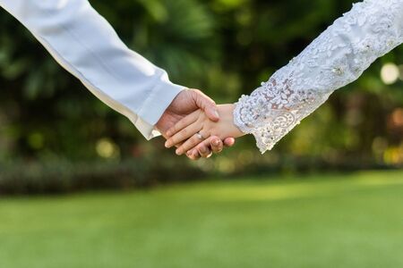 bride and groom hold hand together