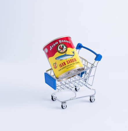 Kuala Lumpur, Malaysia - April 16, 2020 : View a Sardines (Ayam Brand) inside mini shopping chart over white backgroundのeditorial素材