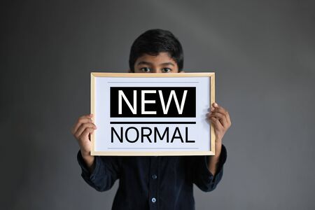 NEW NORMAL. Asian Boy wearing Medical Masks and show on sign