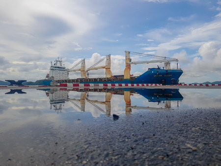 CHONBURI, THAILAND - MAY 24, 2018 : Blue and white cargo ship leaves port at Chuk Samet Deep sea port on May 24, 2018 in Chonburi, Thailand.のeditorial素材