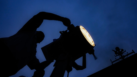 Sailor sends mos code via flashing light during ship's underway.