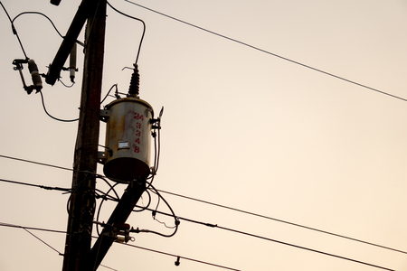 Old and vintage electric transformer on electricity post with electricity wires and other components...