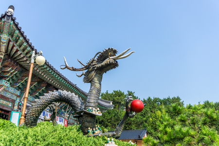 BUSAN, SOUTH KOREA - JULY 20, 2017 : Metal sculpture of Chinese dragon holding red ball at Haedong Yonggungsa Temple on July 20, 2017 in Busan, South Korea.のeditorial素材