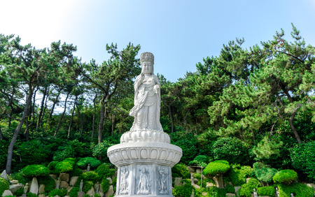 BUSAN, SOUTH KOREA - JULY 20, 2017 : Guanyin or Guan Yin Goddess of Mercy white stone statue on the top of the hill at Haedong Yonggungsa Temple on July 20, 2017 in Busan, South Korea.のeditorial素材