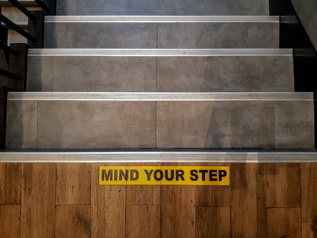 Mind Your Step sign printed on the tile floor over the staircase with modernize decorative style.の写真素材