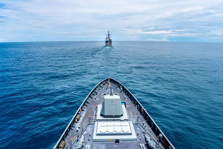 Navy modern stealth frigate sail along the calm sea behide the cruiser type warship,view from bow.の素材 [FY310141785333]