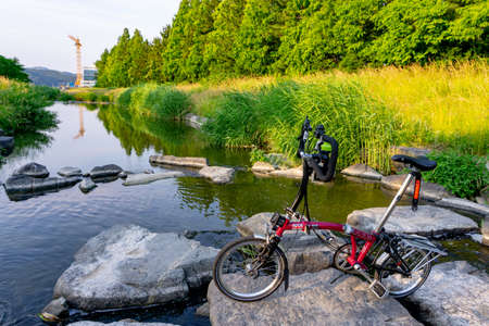 GEOJE, SOUTH KOREA - JUNE 15, 2017: Brompton folding bike park in front of the small stream in the...