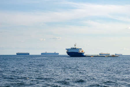 Project cargo ship anchors in the open sea among the several types of commercial ships.の写真素材