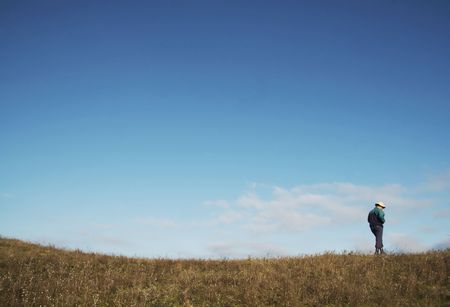 Men going up on the green hillの写真素材