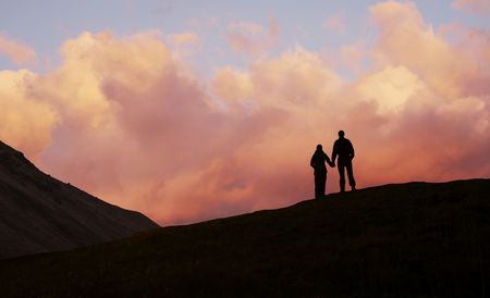 Girl and boy silhouette on the sunset backgroundの写真素材