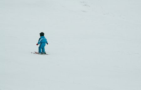Little skier on snow slopeの写真素材