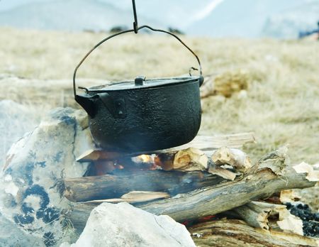 Campfire and kitchenware in mountainの写真素材
