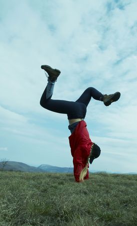 Girl in red clothing is doing cartwheelの写真素材